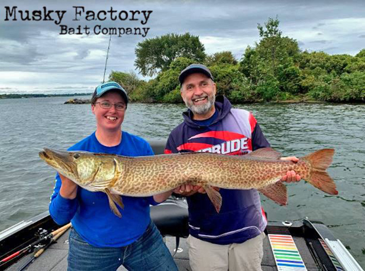 Image of the Musky Factory Bait Company Abigale Culberson and Lawrence Gunther holding a large musky